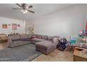 Spacious living room features tile flooring, a ceiling fan, and natural light at 19719 N Castille Dr, Maricopa, AZ 85138