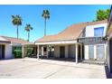 Attractive property with a covered parking area and desert landscaping, enhanced by tall palm trees at 2416 W Caribbean Ln # 2, Phoenix, AZ 85023