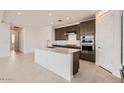 Bright kitchen featuring stainless steel appliances, a center island with quartz countertops, and sleek cabinets at 25347 N 176Th Ave, Surprise, AZ 85387