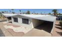 Manufactured home featuring covered parking and awning, enhanced by well-kept landscaping at 3104 E Broadway Rd # 268, Mesa, AZ 85204