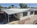 Manufactured home featuring awning, well-maintained exterior, and neatly landscaped yard at 3104 E Broadway Rd # 268, Mesa, AZ 85204