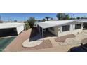 Manufactured home with covered parking and an awning, surrounded by well-maintained landscaping at 3104 E Broadway Rd # 268, Mesa, AZ 85204