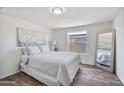 Comfortable bedroom featuring wood floors, natural light, and a decoratively framed mirror at 320 E Mckellips Rd # 25, Mesa, AZ 85201