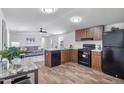 Well-lit kitchen featuring wood cabinets, black appliances, and an open floor plan to the living area at 320 E Mckellips Rd # 25, Mesa, AZ 85201