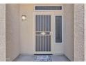 Close-up of a secure front door with a decorative security screen, sidelight and welcome mat at 3882 S Hawthorn Dr, Chandler, AZ 85248