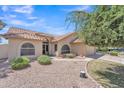 Inviting home entrance showcasing arched windows, desert landscaping, and a well-maintained walkway at 3882 S Hawthorn Dr, Chandler, AZ 85248