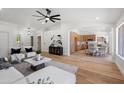 Bright, open-concept living room featuring a large ceiling fan and wood-look floors, seamlessly connected to the kitchen at 4439 W Cielo Grande --, Glendale, AZ 85310