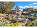 A view of the community fountain with condos and parking spaces in the background with mountain views at 7557 N Dreamy Draw Dr # 154, Phoenix, AZ 85020