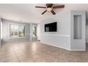 The light blue living room includes tile flooring, a ceiling fan, and bright windows at 9142 W Pontiac Dr, Peoria, AZ 85382