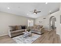 Bright living room with plush sofas, a ceiling fan, neutral walls, and wood-look flooring at 1030 S Brentwood Ct, Chandler, AZ 85286