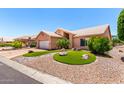 Inviting single-Gathering home with landscaped front yard, synthetic grass, and stone features at 15073 W Piccadilly Rd, Goodyear, AZ 85395