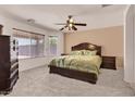 Cozy bedroom featuring a large bed, plush carpet, and a ceiling fan at 1623 E Maplewood Ave, Buckeye, AZ 85326