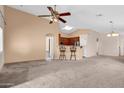 Open-concept living room with carpet and an eat-in kitchen with barstool seating at 1623 E Maplewood Ave, Buckeye, AZ 85326