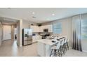 Modern kitchen featuring stainless appliances, white cabinets, quartz countertops, and bar stool seating at 17387 W Whispering Wind Rd, Surprise, AZ 85387