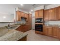 Kitchen featuring granite countertops, wooden cabinets and black appliances at 1851 W Vermont Ave, Phoenix, AZ 85015