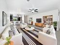 Bright living room with stylish furniture, modern ceiling fan, and open layout flowing into kitchen and dining areas at 1953 W Stage Driver St, Apache Junction, AZ 85120