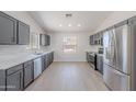 A spacious kitchen boasts gray cabinets, stainless steel appliances, and bright countertops, filled with light at 23852 W La Salle St, Buckeye, AZ 85326