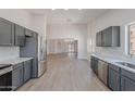 Spacious kitchen with stainless steel appliances, light countertops, gray cabinets, and an eat-in area at 23852 W La Salle St, Buckeye, AZ 85326