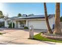 Charming home featuring well-maintained landscaping, solar panels, and a brick driveway at 4046 E Crocus Dr, Phoenix, AZ 85032