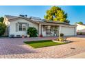 Charming home featuring well-maintained landscaping, solar panels, and a brick driveway at 4046 E Crocus Dr, Phoenix, AZ 85032