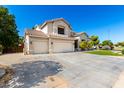 Side view of home with large driveway, three-car garage, tile roof and desert landscaping at 4530 E Decatur St, Mesa, AZ 85205