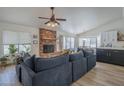 Comfortable living room with a brick fireplace, adjacent to the dining area and kitchen at 5919 W Blackhawk Dr, Glendale, AZ 85308