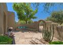 Charming courtyard with a built-in bench, decorative pillows, and lush desert plants at 8306 E Buckskin Trl, Scottsdale, AZ 85255
