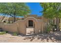 Inviting front entrance with desert landscaping, stone accents, and an arched entryway at 8306 E Buckskin Trl, Scottsdale, AZ 85255
