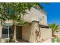 Exterior of home with pale stucco walls, front security door, palm trees and utility box at 9011 N 52Nd Ave, Glendale, AZ 85302