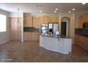 Open kitchen with a breakfast bar, light wood cabinets, granite counters, and stainless steel appliances at 9018 W Superior Ave, Tolleson, AZ 85353