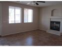 Spacious living room with tile floors, a modern fireplace, and natural light at 9018 W Superior Ave, Tolleson, AZ 85353