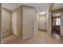 Neutral hallway with ceramic tile flooring leading to a bright entryway and bedrooms at 9926 W Gross Ave, Tolleson, AZ 85353