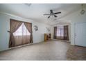 Bright living room with tile floors, ceiling fan, and neutral walls at 10618 W Pima St, Tolleson, AZ 85353