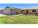 Beautiful single-story home with solar panels, charming porch, and verdant lawn at 10651 W Saratoga Cir, Sun City, AZ 85351
