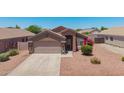 A house with desert landscaping in the front yard featuring shrubbery and colorful blooms at 16264 W Pioneer St, Goodyear, AZ 85338
