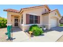 Welcoming home entrance with desert landscaping and a whimsical cactus statue at 17449 N Fairway Dr, Surprise, AZ 85374