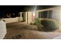 A beautiful home exterior at dusk, featuring a paver driveway and a brightly-colored red front door at 3109 E Cholla St, Phoenix, AZ 85028