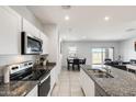 Bright kitchen with granite countertops, stainless steel appliances, and white cabinetry offering a clean and modern design at 35816 W San Ildefanso Ave, Maricopa, AZ 85138