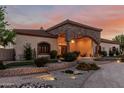 Beautiful exterior featuring stone accents, an arched entrance, and a meticulously landscaped front yard at 3718 N Briere Ct, Buckeye, AZ 85396