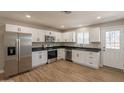 Modern kitchen with white cabinets, stainless steel appliances, black countertops, and tile flooring at 4001 E Apollo Rd, Phoenix, AZ 85042