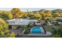 Gorgeous pool with mature trees, patio, and fencing to create a serene outdoor space at 4856 E Cheryl Dr, Paradise Valley, AZ 85253