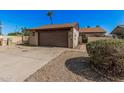 Charming single-story home with a two-car garage, featuring a low-maintenance gravel yard and mature landscaping at 5101 W Purdue Ave, Glendale, AZ 85302