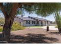 Single story home with desert landscaping, white painted brick, and a dark roof at 5102 W Whispering Wind Dr, Glendale, AZ 85310