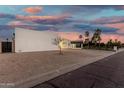 Modern desert home with a three-car garage, covered porte cochere, and desert landscaping at 6401 E Larkspur Dr, Scottsdale, AZ 85254
