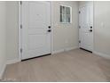 The tiled entryway has two white doors with black hardware and a small window at 7448 S 75Th Ln, Laveen, AZ 85339