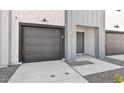 View of the home's attached garage and front entry, with a contemporary design and neutral color palette at 7448 S 75Th Ln, Laveen, AZ 85339