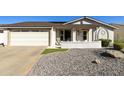 Charming front exterior featuring a well-manicured yard, covered porch, and two-car garage at 922 S Ember Cir, Mesa, AZ 85208
