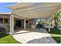 Spacious covered patio with an outdoor kitchen, grill, and ample seating area at 922 S Ember Cir, Mesa, AZ 85208