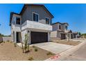 Street view of stucco homes with grey siding, dark garage doors, desert landscaping, and concrete driveways at 9408 E Sequence Ave, Mesa, AZ 85212