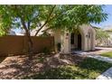 Attractive single-story home with desert landscaping, arched porch, and mature trees in a sunny setting at 9412 S 34Th Dr, Laveen, AZ 85339
